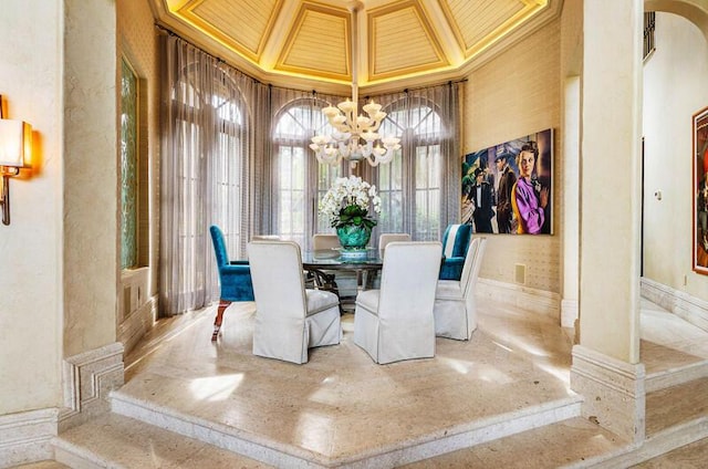 dining space with a notable chandelier, ornamental molding, a high ceiling, and wooden ceiling