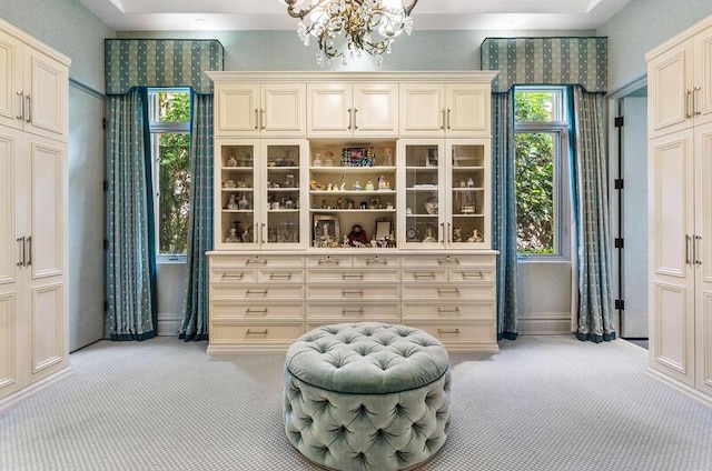 living area featuring light colored carpet and an inviting chandelier