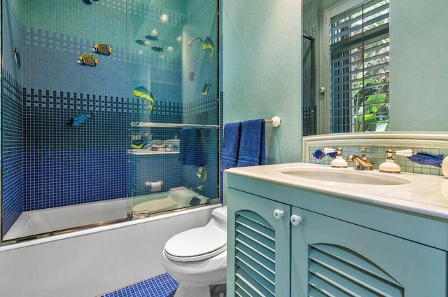 full bathroom with vanity, tile patterned floors, decorative backsplash, toilet, and enclosed tub / shower combo