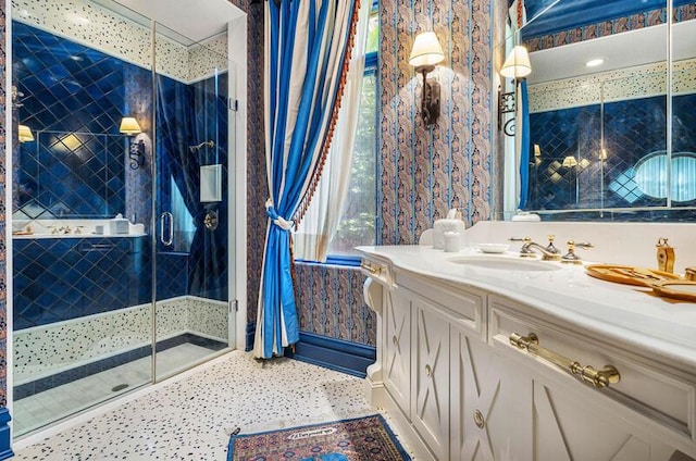 bathroom featuring a shower with door and vanity