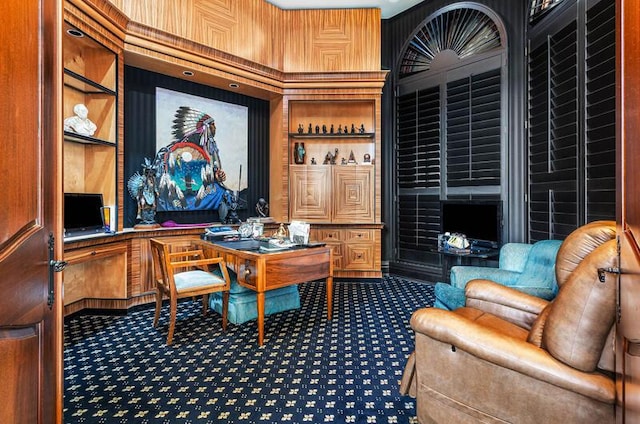 office area featuring carpet, wood walls, and built in features