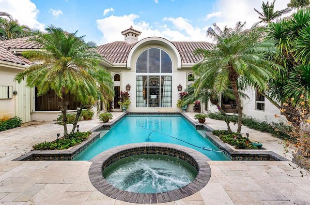 view of pool with an in ground hot tub and a patio area