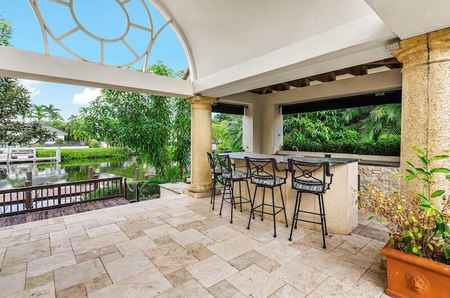 view of patio / terrace featuring a water view and an outdoor bar