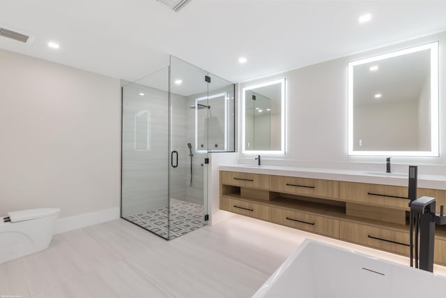 bathroom featuring vanity, a shower with shower door, and toilet