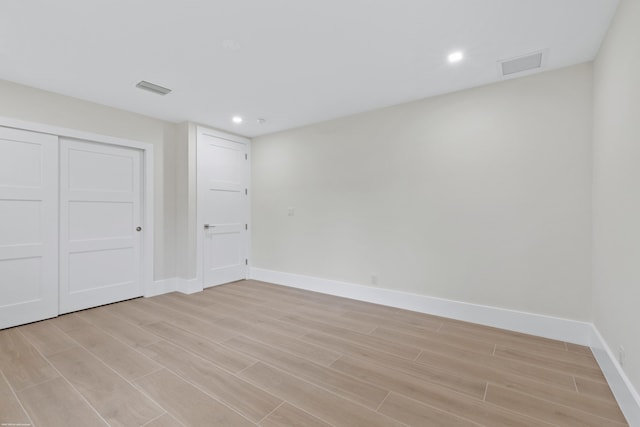 unfurnished bedroom with light hardwood / wood-style flooring and a closet