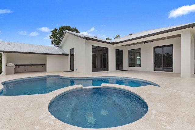 view of pool with an in ground hot tub, an outdoor kitchen, ceiling fan, and a patio area