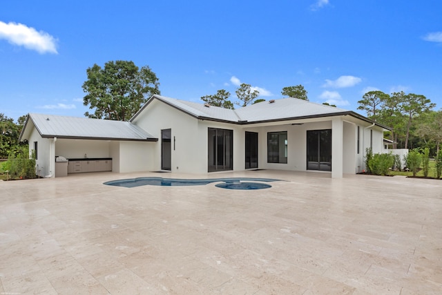 rear view of house featuring a fenced in pool, a patio area, ceiling fan, and exterior kitchen