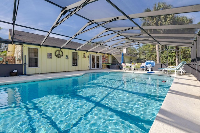 view of pool featuring glass enclosure and a patio