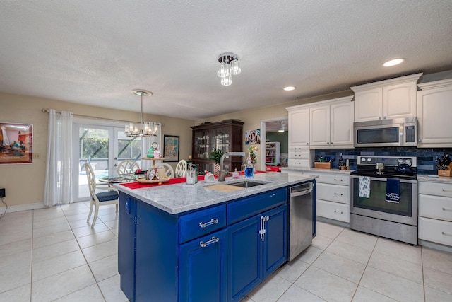 kitchen with backsplash, stainless steel appliances, blue cabinets, and white cabinetry