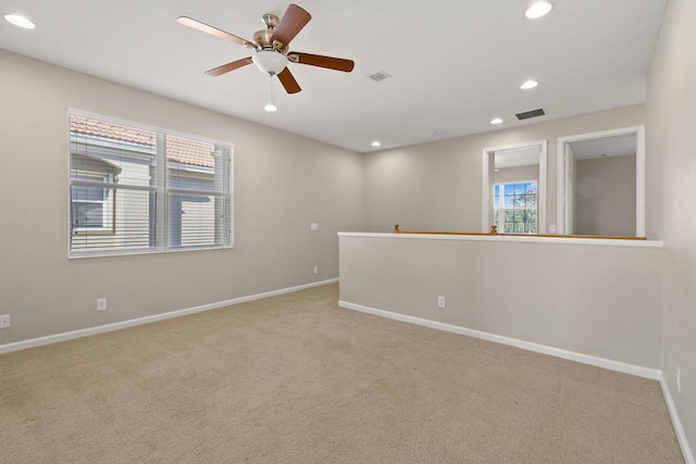 carpeted spare room featuring ceiling fan