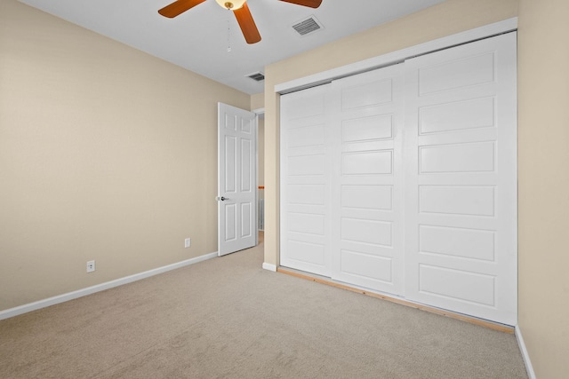 unfurnished bedroom with ceiling fan, a closet, and light colored carpet