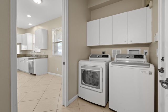 clothes washing area featuring cabinets, sink, separate washer and dryer, and light tile patterned flooring