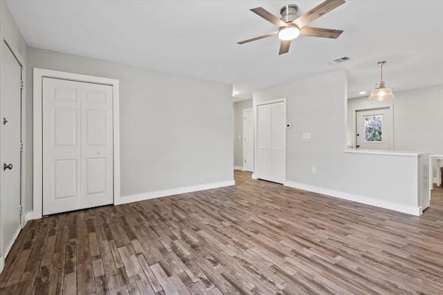 unfurnished living room featuring ceiling fan and wood-type flooring