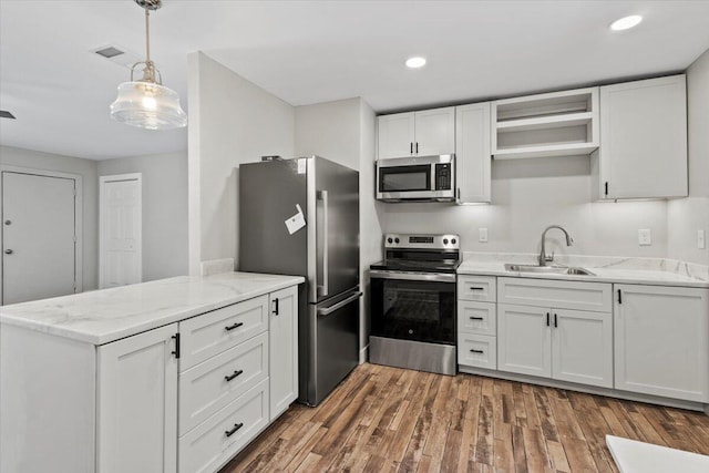 kitchen featuring white cabinetry, sink, hardwood / wood-style floors, and appliances with stainless steel finishes