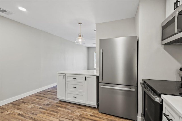 kitchen featuring light wood-type flooring, white cabinetry, and appliances with stainless steel finishes