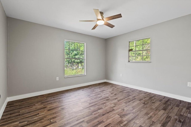 empty room with ceiling fan, dark wood-type flooring, and a healthy amount of sunlight