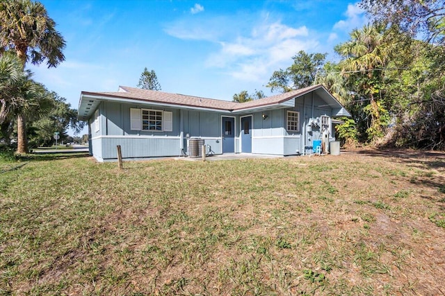 ranch-style home with a front lawn and central AC unit