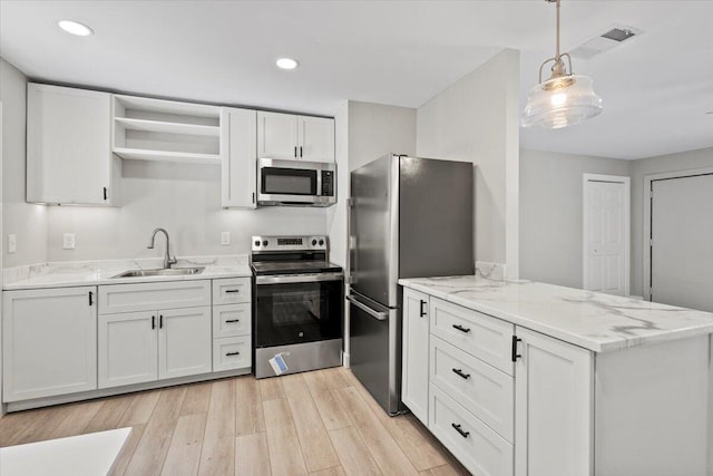 kitchen featuring white cabinets, light wood-type flooring, stainless steel appliances, and sink