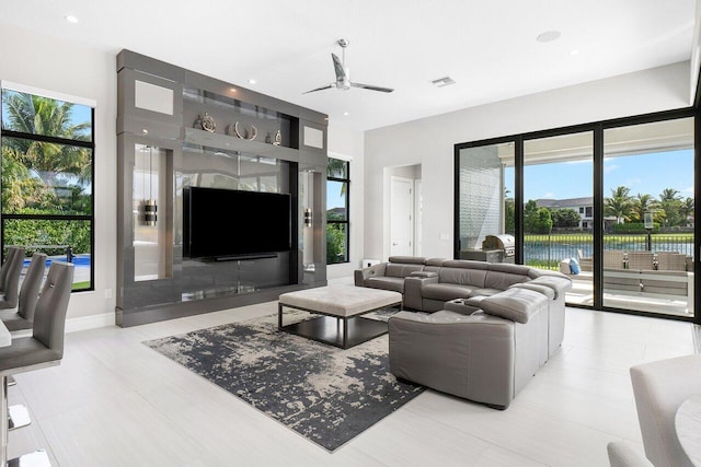 living room featuring ceiling fan and a wealth of natural light