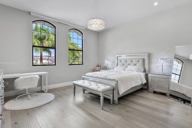 bedroom featuring a chandelier and light hardwood / wood-style flooring