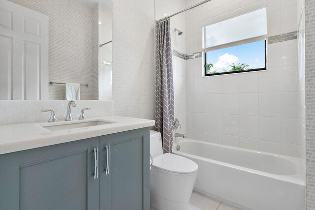 full bathroom featuring tile patterned floors, shower / bath combination with curtain, toilet, and vanity