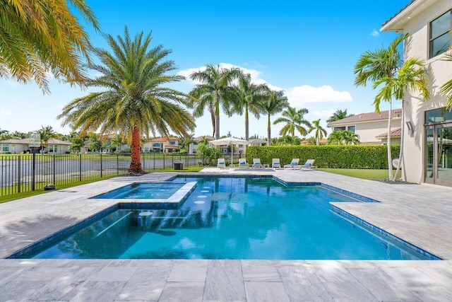 view of swimming pool featuring a patio area and an in ground hot tub