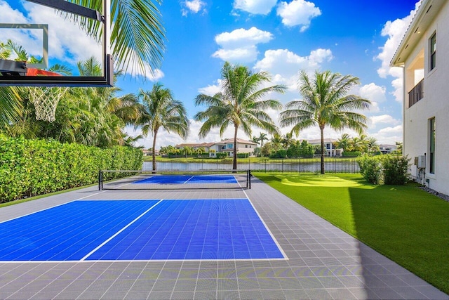 view of tennis court with basketball court, a yard, and a water view