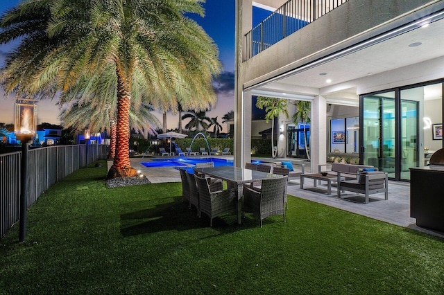 yard at dusk with a fenced in pool, pool water feature, and a patio