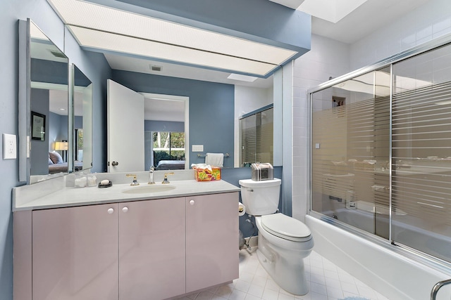 full bathroom with tile patterned flooring, toilet, vanity, and combined bath / shower with glass door