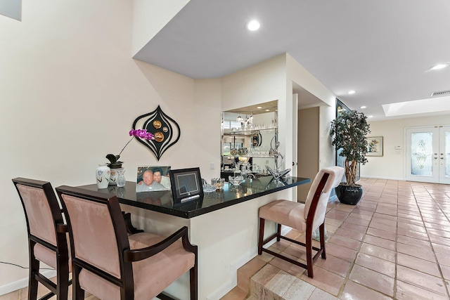 dining room with french doors, light tile patterned floors, and indoor bar