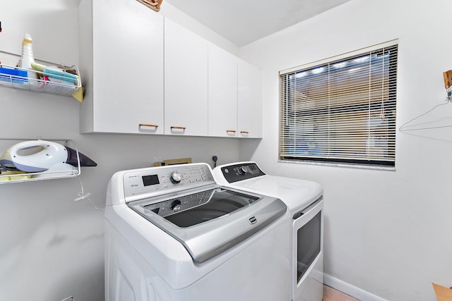 washroom featuring cabinets and washing machine and clothes dryer