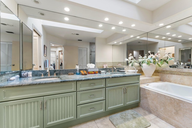 bathroom featuring tile patterned floors, a skylight, vanity, and shower with separate bathtub