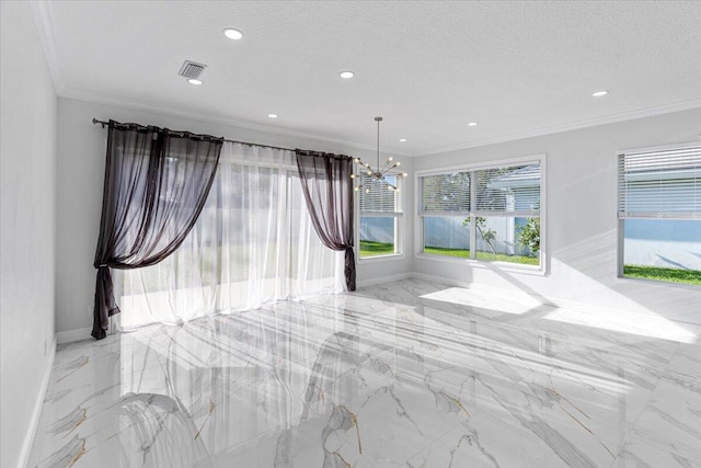 spare room featuring a chandelier, a textured ceiling, and ornamental molding