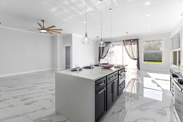 kitchen featuring pendant lighting, a textured ceiling, a kitchen island with sink, and ornamental molding