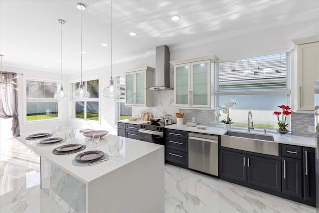 kitchen with a center island, sink, hanging light fixtures, wall chimney exhaust hood, and stainless steel appliances