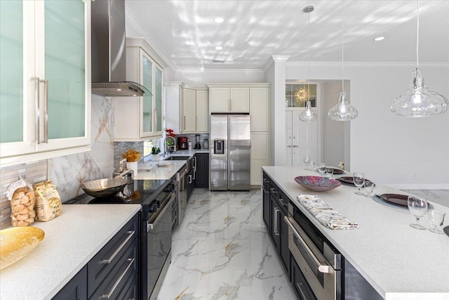 kitchen with sink, wall chimney exhaust hood, stainless steel appliances, tasteful backsplash, and pendant lighting