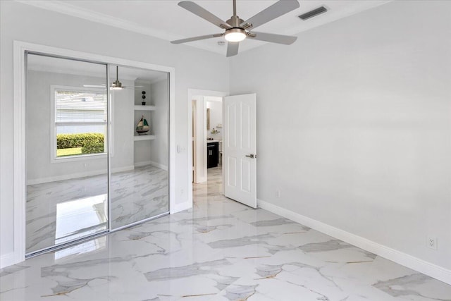 unfurnished bedroom featuring ceiling fan, a closet, and crown molding