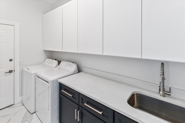 clothes washing area featuring cabinets, sink, and washing machine and clothes dryer