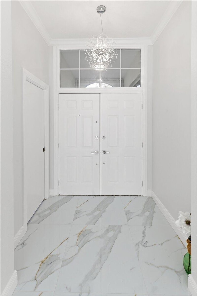 entryway with crown molding and a chandelier