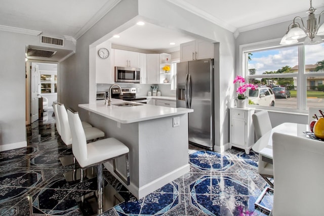 kitchen with kitchen peninsula, appliances with stainless steel finishes, crown molding, decorative light fixtures, and white cabinets