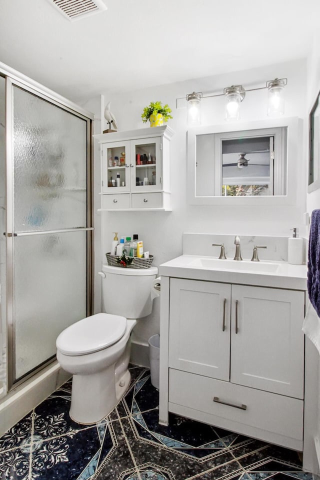 bathroom with vanity, toilet, and an enclosed shower