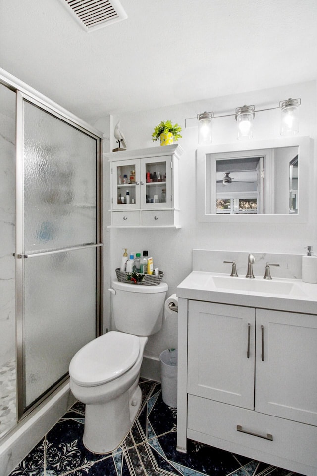 bathroom featuring a shower with door, vanity, and toilet