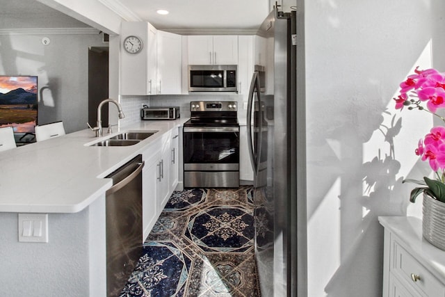 kitchen with white cabinets, sink, decorative backsplash, kitchen peninsula, and stainless steel appliances