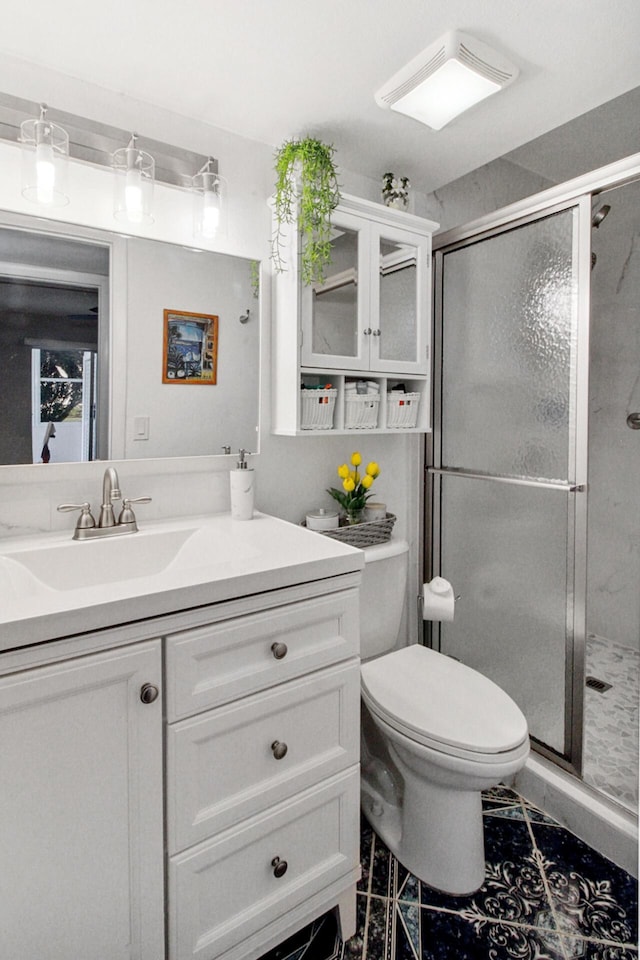 bathroom with a shower with door, vanity, and toilet