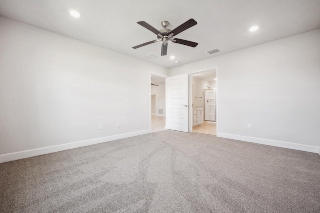 unfurnished bedroom featuring ceiling fan, light colored carpet, and connected bathroom