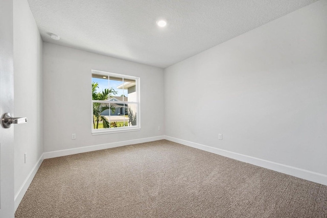 unfurnished room with carpet floors and a textured ceiling