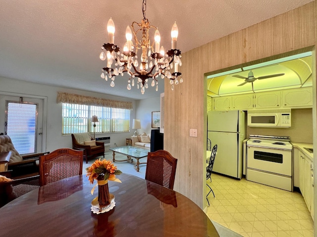 dining room with a textured ceiling and ceiling fan with notable chandelier