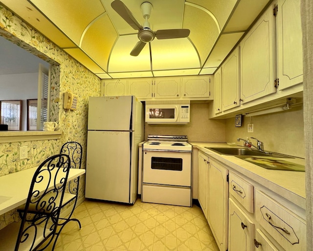 kitchen with white appliances, ceiling fan, and sink