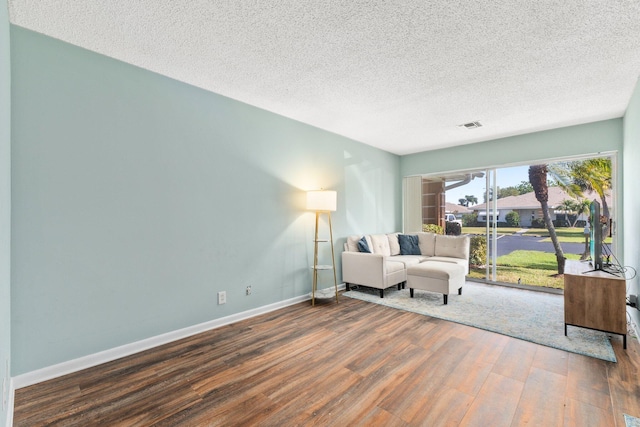 living area with wood-type flooring and a textured ceiling