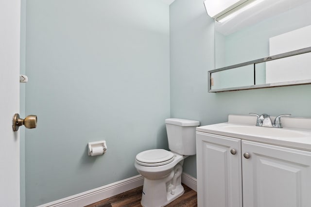 bathroom with hardwood / wood-style floors, vanity, and toilet